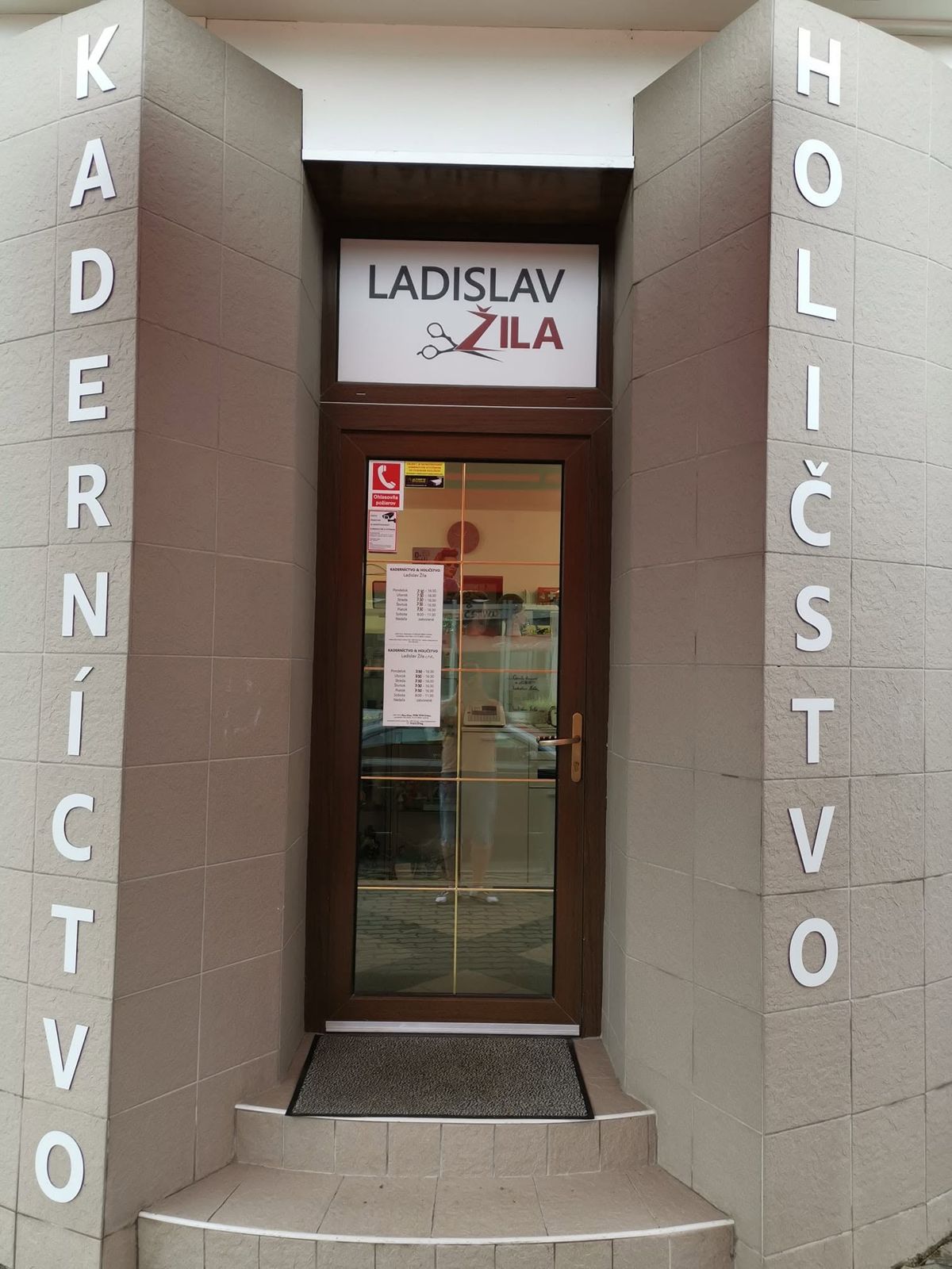 Vchod do prevádzky na Mieru 151/10 v Lučenci, piliere s nápismi Kaderníctvo a Holičstvo